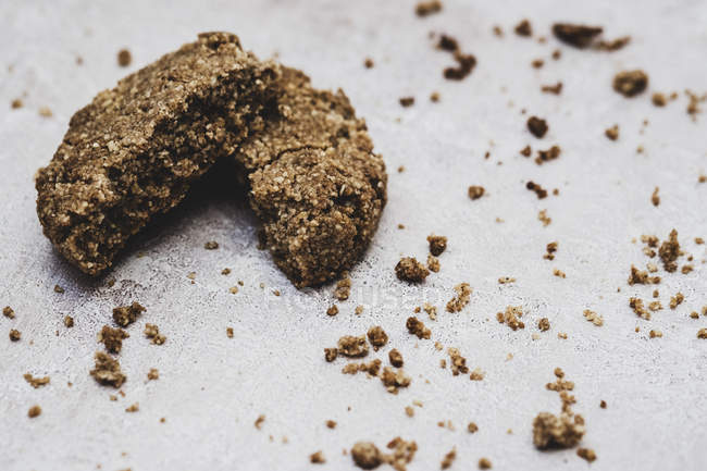 Close-up of a freshly baked chocolate cookie broken in halves and crumbs. — Stock Photo