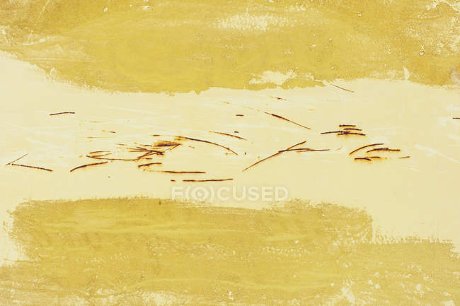 Nahaufnahme von gelber Farbe und rostigen Kratzspuren an der Wand — Stockfoto