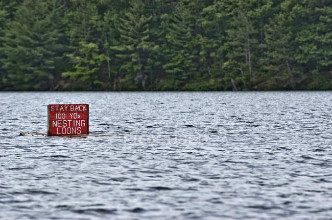 Segnale di avvertimento ornitologico rosso nell'acqua del lago — Foto stock