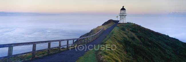Faro del Cabo Reinga al amanecer, Península de Aupouri, Nueva Zelanda - foto de stock