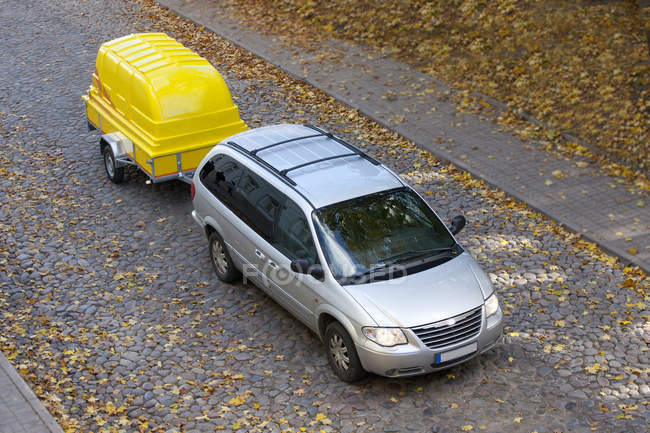 Van towing yellow trailer on road in Tartu, Estonia — Stock Photo