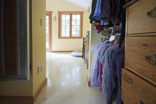 Walk-in closet que conduce al dormitorio en el interior de la casa moderna - foto de stock
