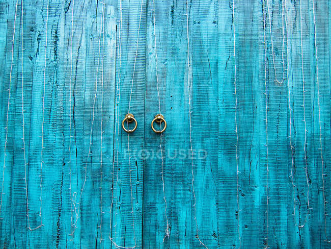 Старые голубые деревянные двери с круглыми дверными ручками — стоковое фото