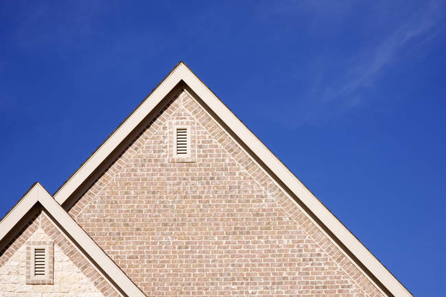 Fascia e cresta di tetto a capanna contro il cielo blu — Foto stock