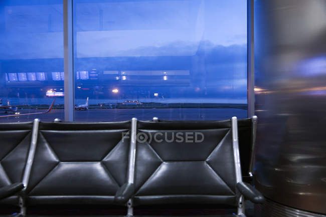 Fenêtre de l'aéroport et circulation sur piste de l'aéroport et voie de circulation au crépuscule . — Photo de stock