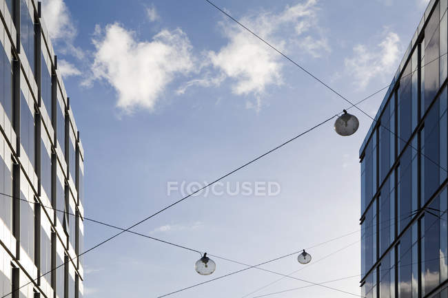 Офісні будівлі екстер'єр з кабелями проти синього неба з хмарами — стокове фото