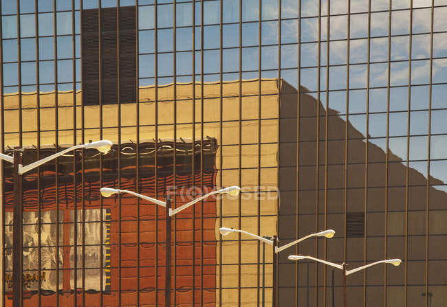 Edifício refletindo em fachada de vidro com janelas — Fotografia de Stock
