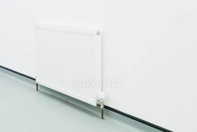 Radiador branco contra parede lisa no quarto — Fotografia de Stock