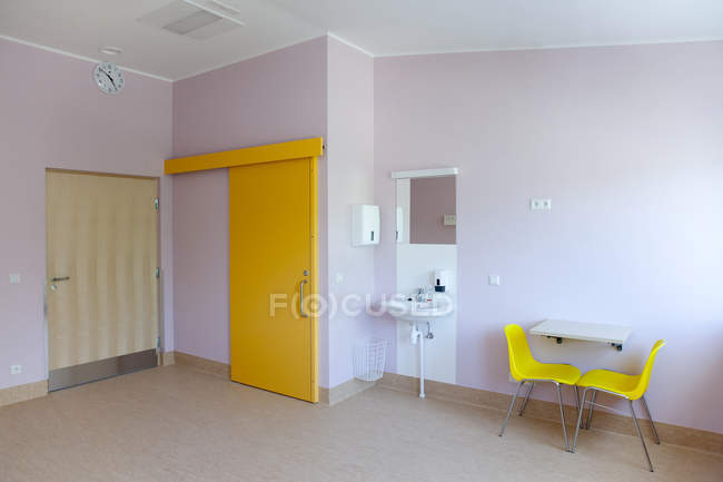 Washing station in hospital room with bright yellow doors — Stock Photo