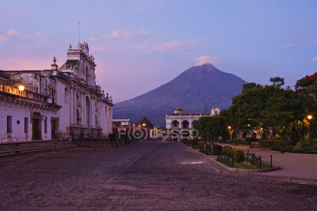 Catedral de San José y volcán Agua a distancia al amanecer, Antigua, Guatemala - foto de stock