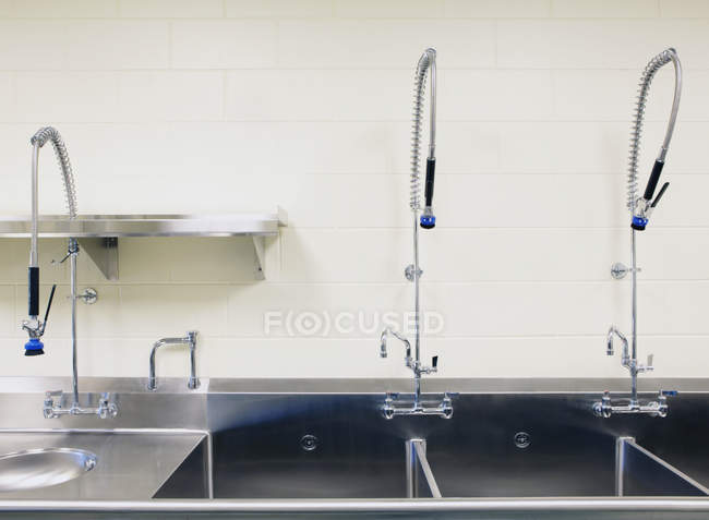 Grandi lavelli industriali e rubinetti in cucina commerciale — Foto stock