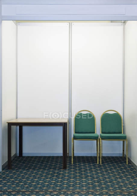Empty exhibition booth with pair of chairs and table in England, United Kingdom — Stock Photo