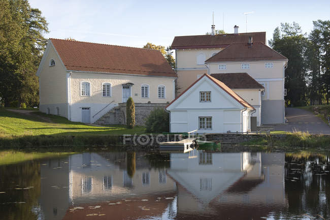 Edifici che si affacciano sulla calma acqua del laghetto di Vihula Manor, Vihula, Estonia — Foto stock