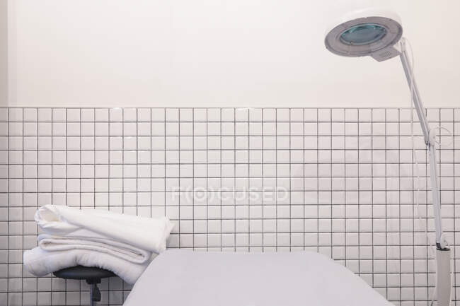 Beautician office with bed, lamp and towels — Stock Photo