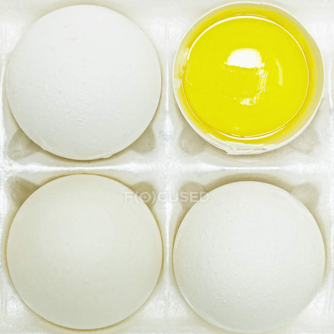 Quatre œufs avec une coupe ouverte avec jaune jaune jaune — Photo de stock