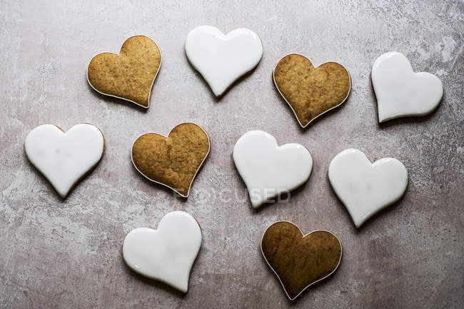 Высокий угол крупный план свежеиспеченного печенья в форме сердца, украшенного белой глазурью . — стоковое фото