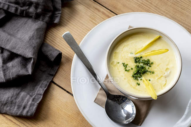 High angle close-up of bowl of soup on wooden table. — Stock Photo