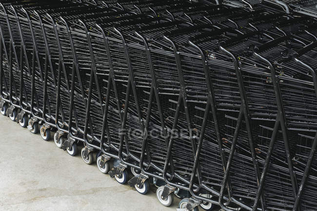 Carritos de supermercado apilados juntos, cuadro completo . - foto de stock