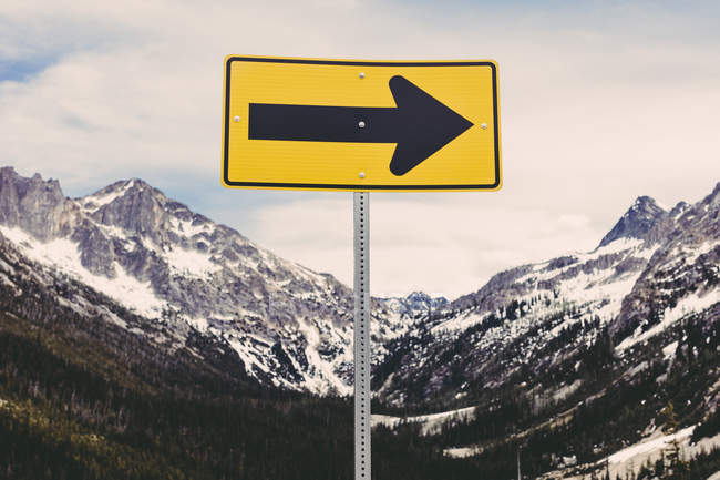 Directional arrow sign in snow covered mountain range, North Cascades, Washington, USA — Stock Photo