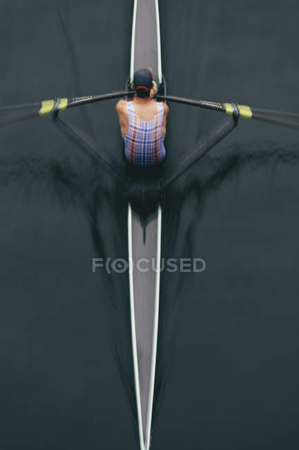 Ansicht des Ruderers im Ruderboot auf ruhigem Wasser bei mittlerem Ruderschlag, Bewegungsunschärfe. — Stockfoto