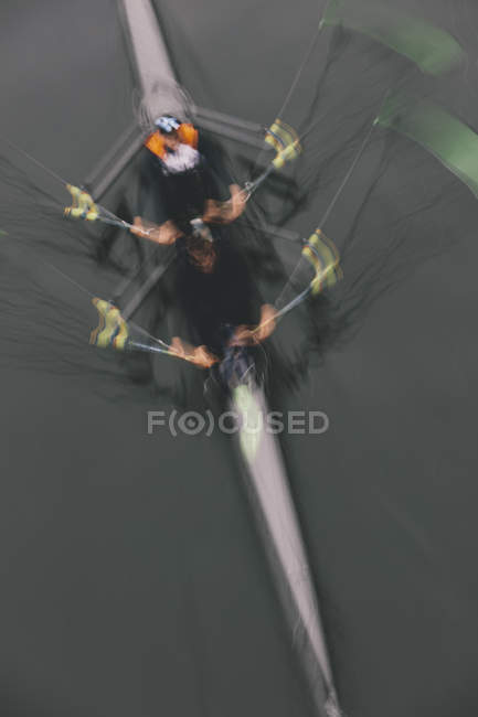 Blurred motion overhead view of double scull boat, two oarsmen in sculling boat on water. — Stock Photo