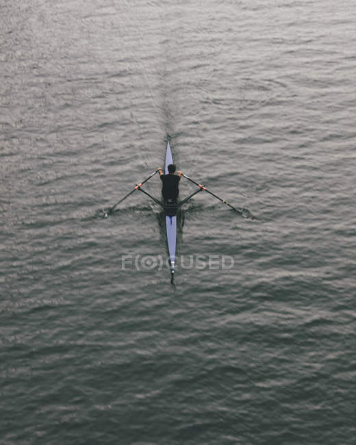 Vista aerea del rematore in barca a scafo singolo su acque calme a metà corsa, movimento sfocato . — Foto stock