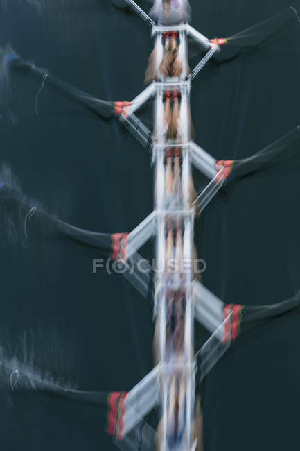 Vista aerea del movimento sfocato dell'equipaggio a remi in barca a remi sull'acqua . — Foto stock