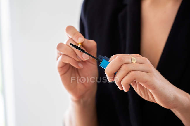 Professional make-up artist at work, using mascara brush in hands. — Stock Photo