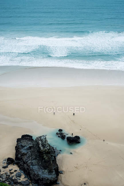 Vista de alto ângulo das ondas oceânicas e rochas na praia de areia, Cornwall, Inglaterra, Reino Unido . — Fotografia de Stock