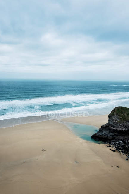 Океанічні хвилі врізаються на піщаний берег під хмарним небом, з високими кутами огляду, Корнуолл, Англія, Велика Британія.. — стокове фото