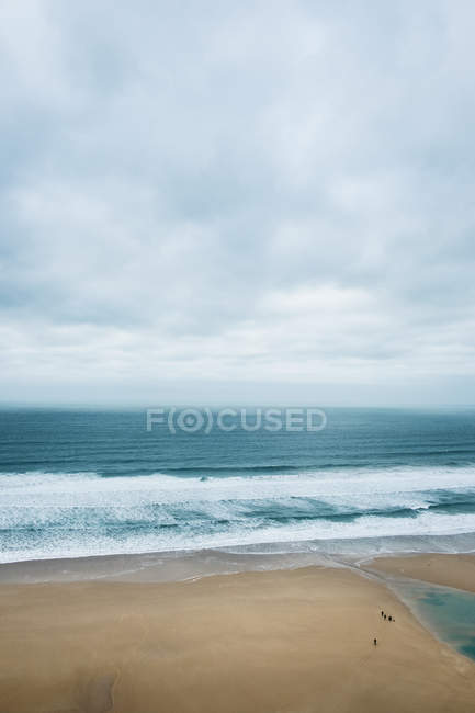 Meereswellen krachen auf Sandstrand unter bewölktem Himmel, Kornwall, England, Vereinigtes Königreich. — Stockfoto