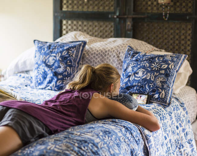 Teenager-Mädchen liegt auf Bett und liest. — Stockfoto