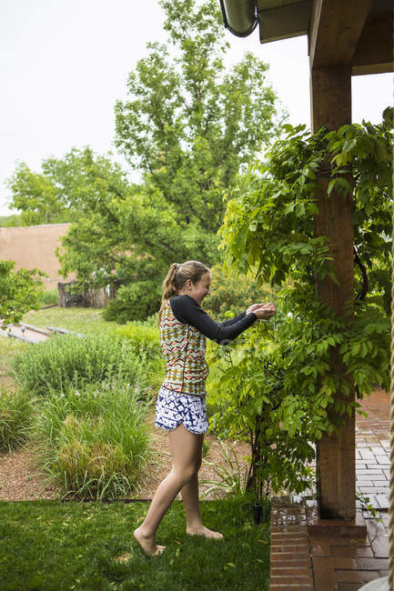 Adolescente ragazza all'aperto in giardino in caso di pioggia . — Foto stock