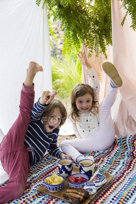 Menino e menina brincando na tenda improvisada ao ar livre — Fotografia de Stock