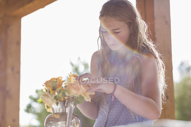 Blondes Teenager-Mädchen arrangiert Rosen aus dem Garten. — Stockfoto