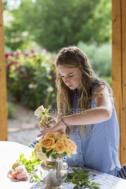 Ragazza bionda adolescente che organizza rose dal giardino formale . — Foto stock