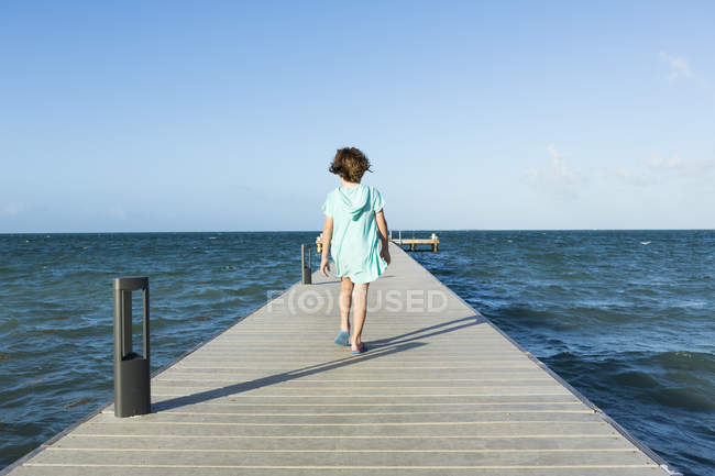 Ragazzo che cammina su un molo di legno, Grand Cayman Island — Foto stock