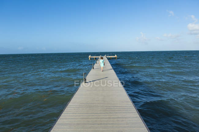 Garçon marchant sur une jetée en bois, île Grand Cayman — Photo de stock