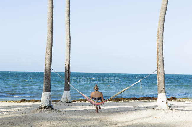 Жінка відпочиває в гамаку в задньому плані, острів Гранд Кайман. — стокове фото