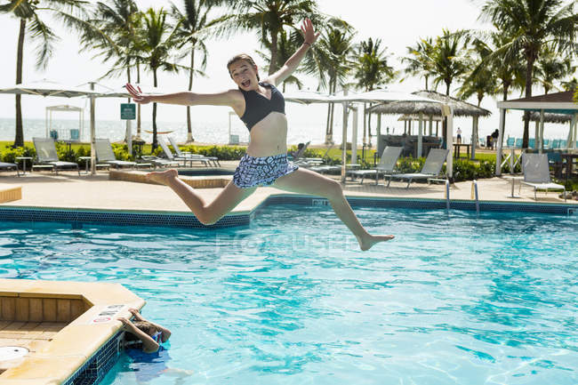 Loira adolescente pulando na piscina . — Fotografia de Stock