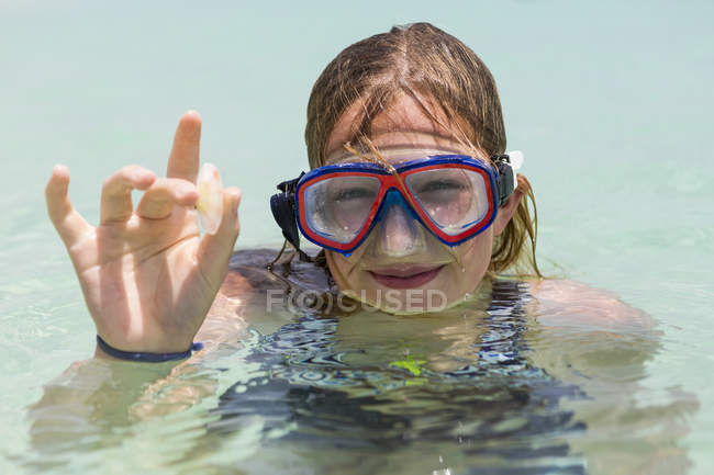 Sorrindo menina adolescente vestindo máscara de snorkel segurando vidro do mar . — Fotografia de Stock
