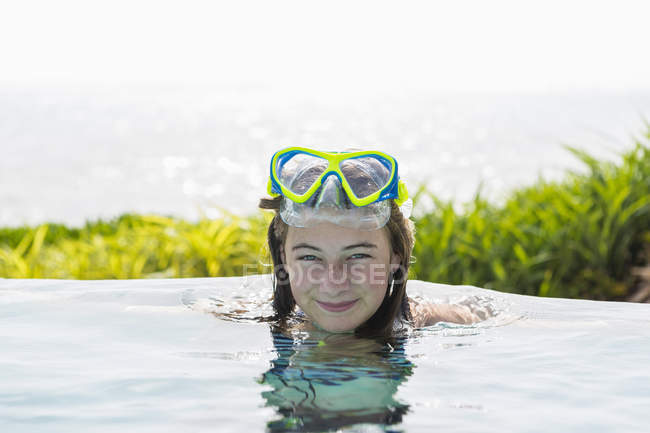 Lächelndes Teenie-Mädchen ruht sich im Schwimmbad aus. — Stockfoto