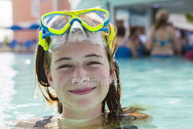 Blonde teenage girl in goggles swimming in infinity pool. — Stock Photo