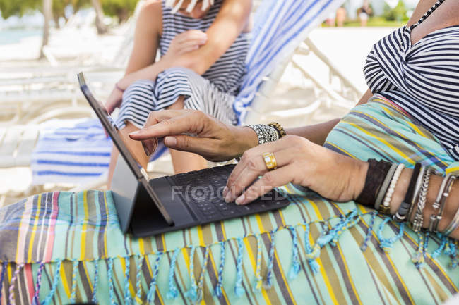 Mains de femme utilisant un ordinateur portable sur la plage, Île Grand Cayman — Photo de stock