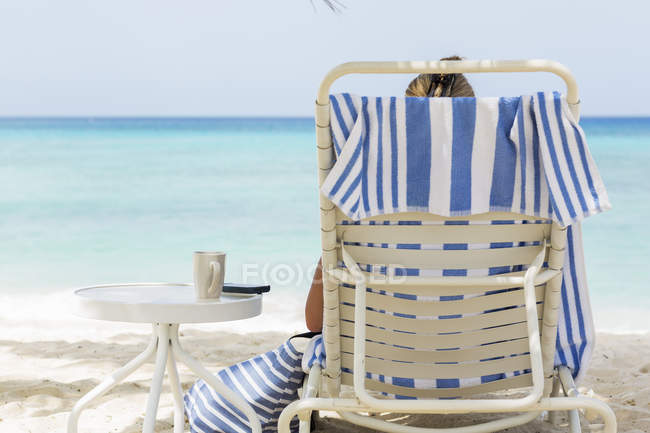 Frau im Stuhl am tropischen Strand, Grand Cayman Island — Stockfoto