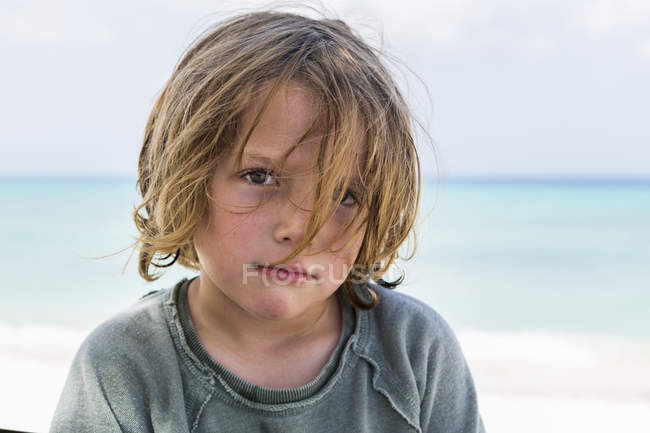 Portrait of preschooler boy with blond messy hair at beach. — Stock Photo