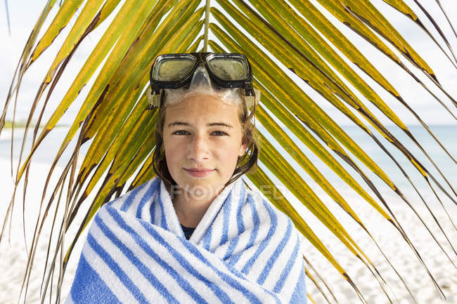 Adolescente in maschera davanti a fronde di palma . — Foto stock