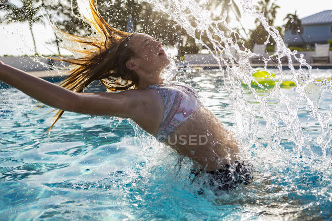 Adolescente jogando cabelo molhado na piscina
. — Fotografia de Stock