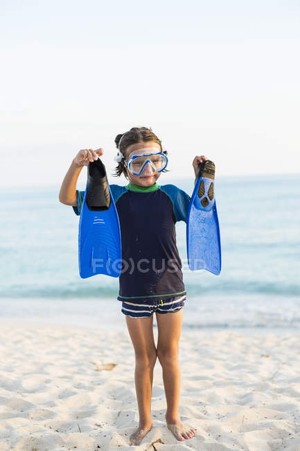 Menino vestindo máscara de snorkel e segurando nadadeiras azuis . — Fotografia de Stock