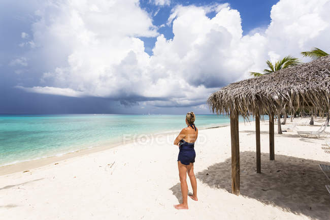 Erwachsene Frau blickt auf nahenden Sturm, Grand Cayman Island — Stockfoto